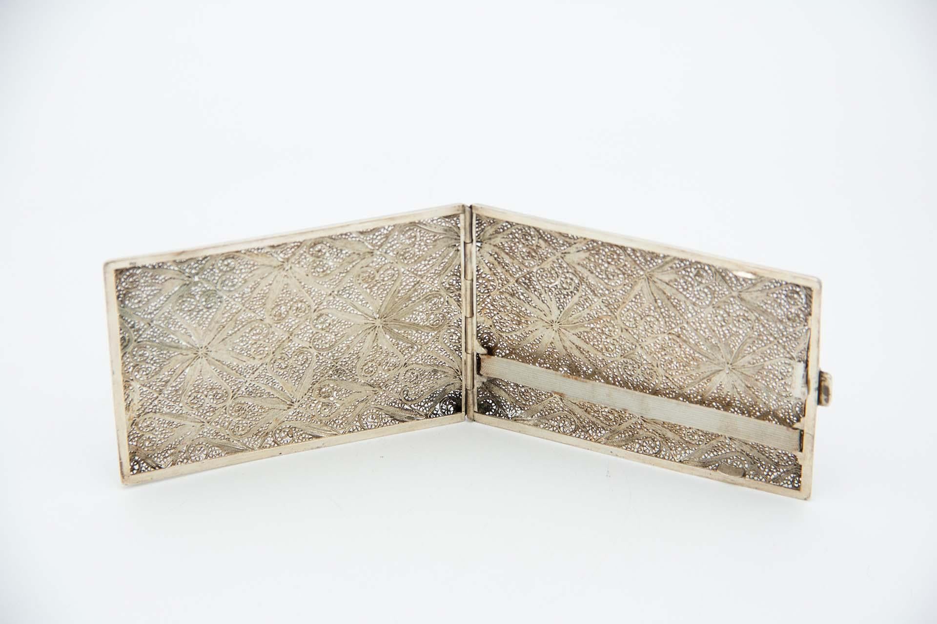 Description: Silver cigarette case in rectangular filigree mesh with spring lid. Metal: Silver. Origin: Portuguese. Brand: Absent. Weight: 134.96 grams. Dimensions: 11.6cmx1.1cm. Content: 833/1000. Assay Mark: Absent. Additional information: Good