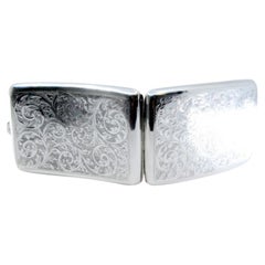 Silver cigarette case w/ curved engravings 
a gold interior w/ a hinged lid