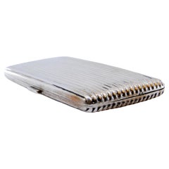 Silver cigarette case w/ fluted bands on both sides, gold interior & hinged lid Silver cigarette case w/ fluted bands on both sides, gold interior & hinged lid