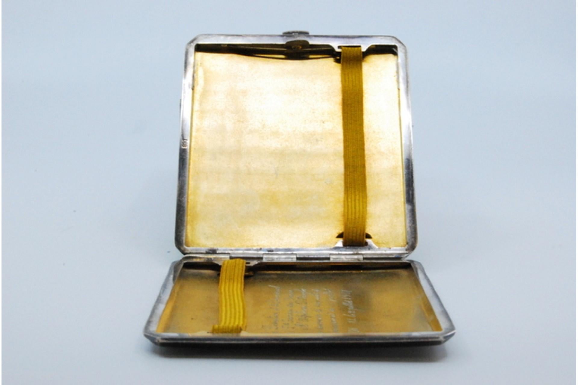 Description: Silver cigarette case with bands along the length, gold interior and hinged lid. Metal: Silver. Origin: Belgian. Brand: Absent. Weight: 96.28 grams. Dimensions: 8.7x0.8cm. Content: 800/1000. Assay Mark: Absent. Additional information:
