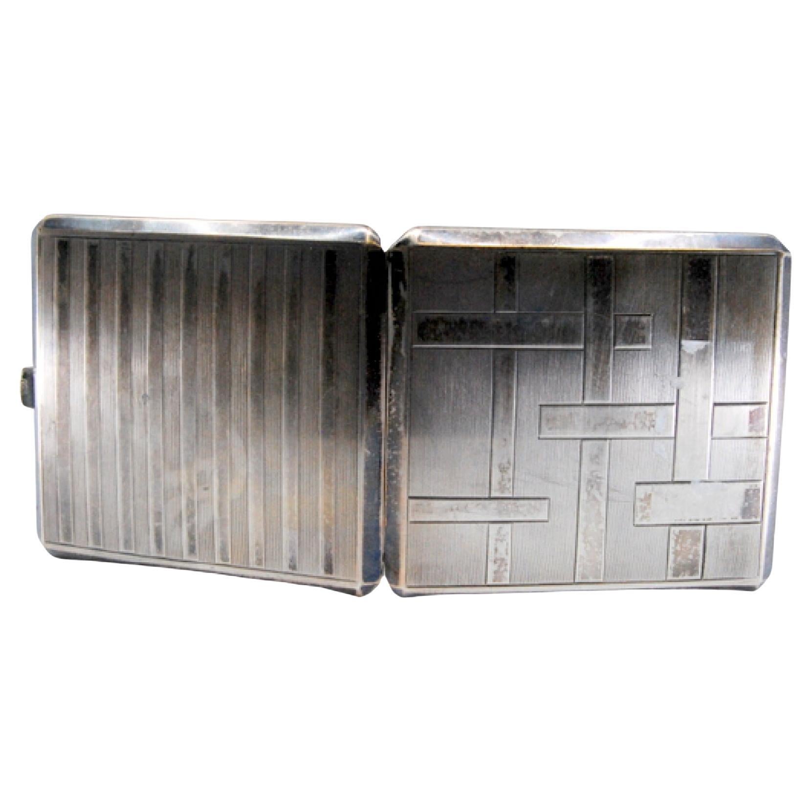 Silver cigarette case with bands along the length, gold interior and hinged lid