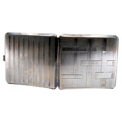 Silver cigarette case with bands along the length, gold interior and hinged lid