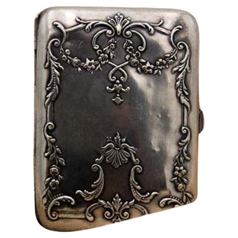 Silver cigarette case with bows, embossed garlands and hinged lid