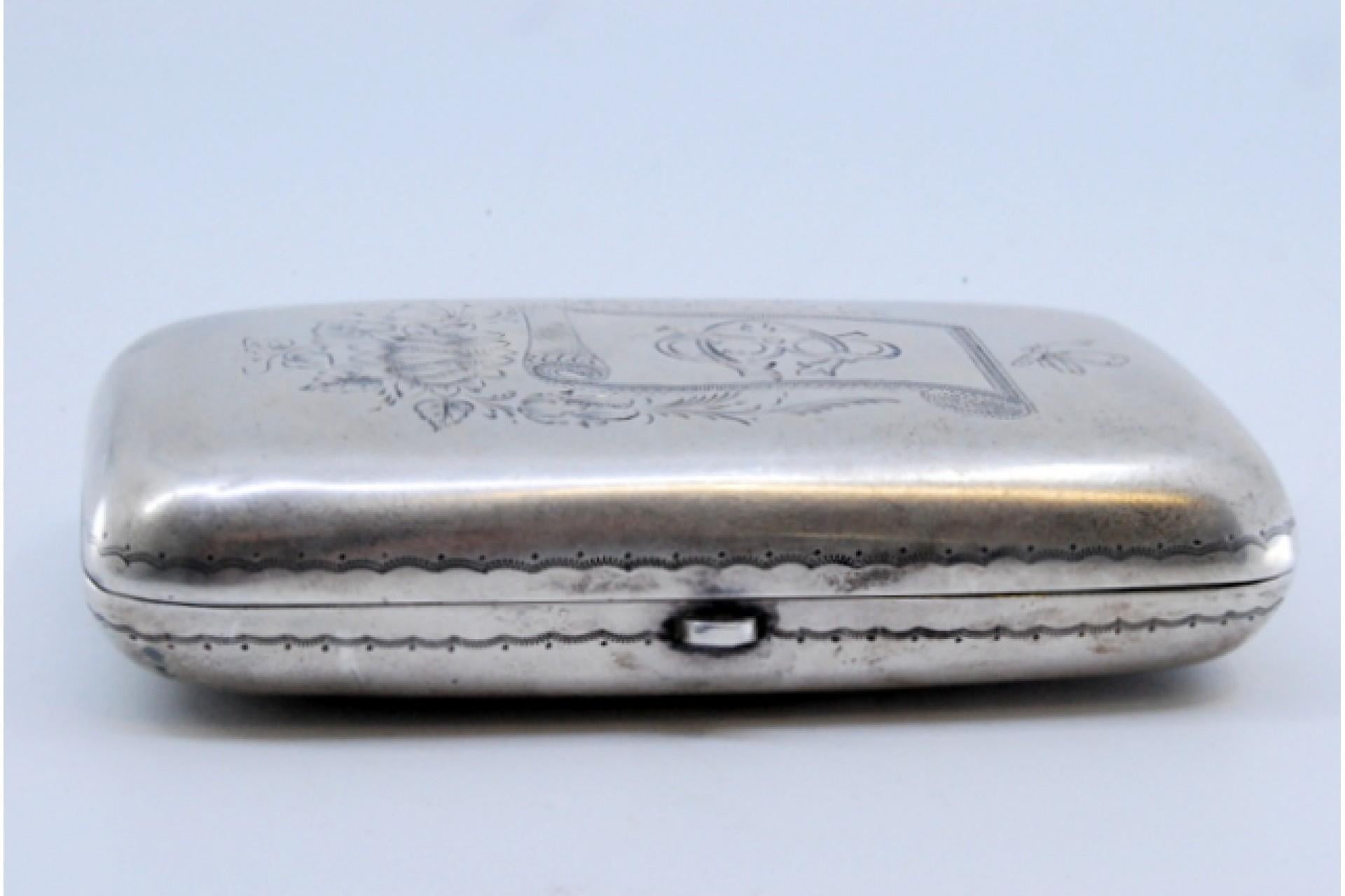 Description : Etui à cigarettes en argent avec applications en relief sur le couvercle et intérieur en or. Métal : Argent. Origine : Portugais. Marque : Eagle Head. Poids : 62,75 grammes. Dimensions : 8,5 x 5,2 cm : 8.5x5.2cm. Contenu : 833/1000.