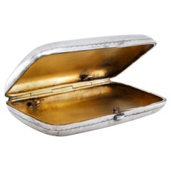 Silver cigarette case with embossed applications on the lid and gold interior Silver cigarette case with embossed applications on the lid and gold interior