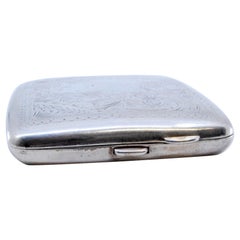 Silver cigarette case with engraved curved wreaths and dividers inside
