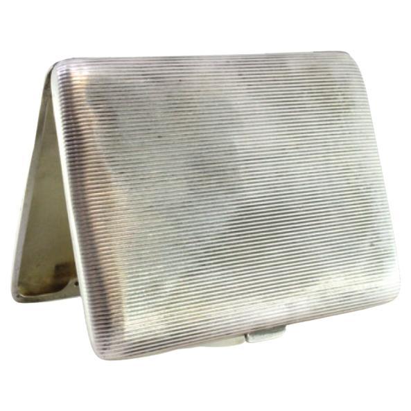 Description: Silver cigarette case, fluted at the top, with a gold-toned interior and a hinged lid. Metal: Silver. Origin: European. Brand: Unknown. Weight: 76.93 grams. Dimensions: 9cmx7cm. Content: 900/1000. Assay Mark: Yes. Additional