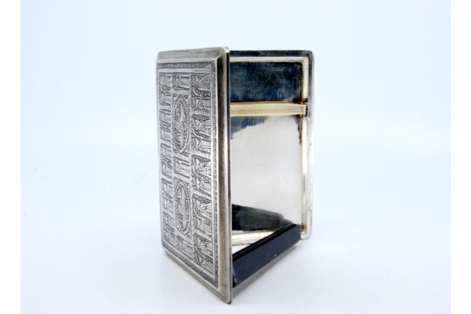 Description: Silver cigarette case with Middle Eastern-style reliefs and hinged lid. Metal: Silver. Origin: Middle East. Brand: Vartan. Weight: 154.63 grams. Dimensions: 10x0.9cm. Content: 900/1000. Assay Mark: Absent. Additional information: Good