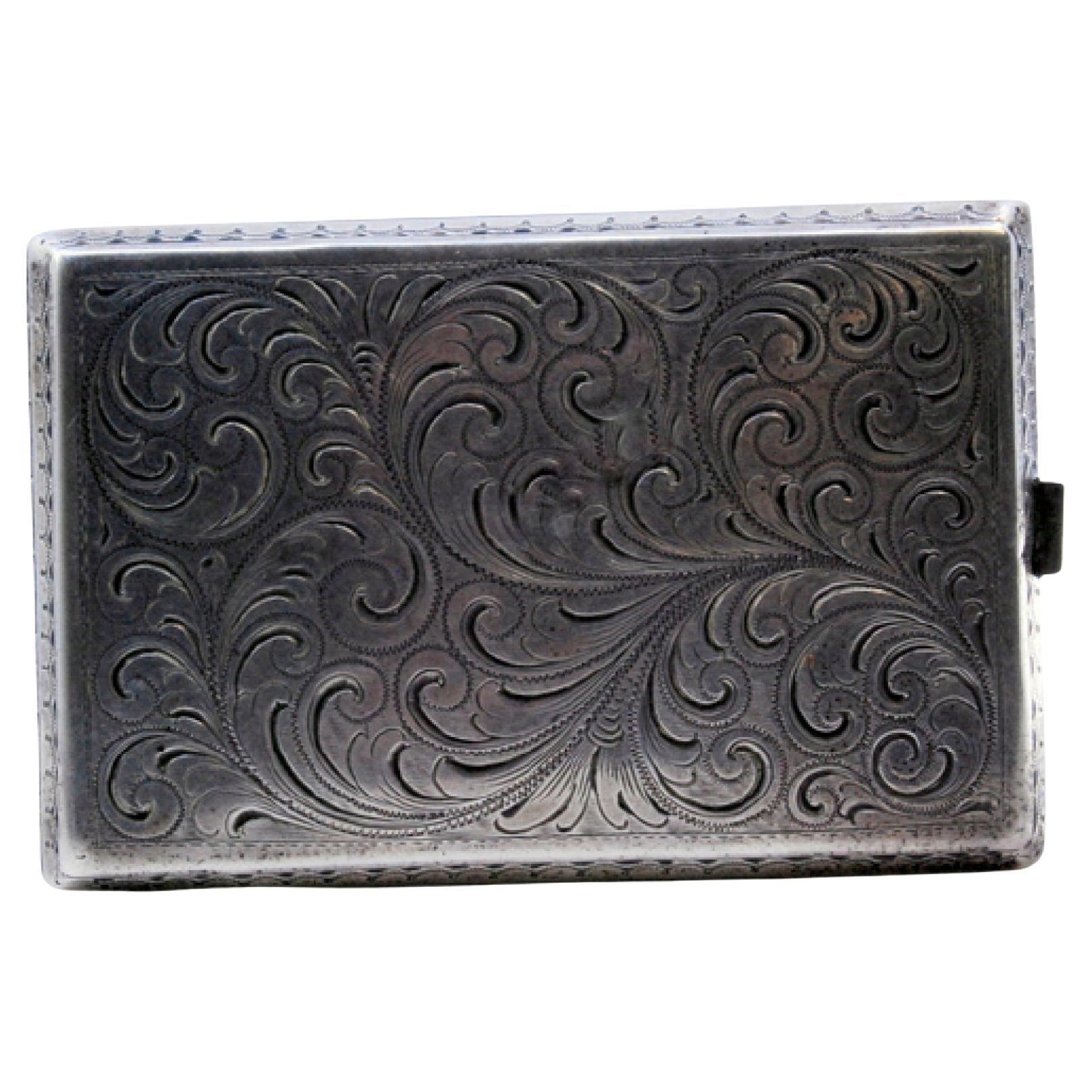 Silver cigarette case with plant engravings, waves on the edge and hinged lid