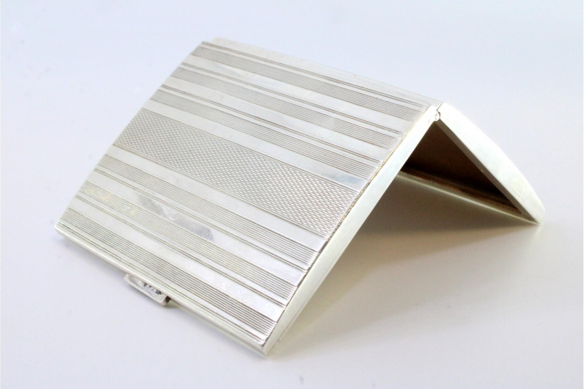 Description: Silver cigarette case with guilloche lid at the top and gold interior. Metal: Silver. Origin: Swedish. Brand: Três Coroas. Weight: 97.07 grams. Dimensions: 8cmx6.5cm. Content: 900/1000. Assay Mark: Yes. Additional information: Good