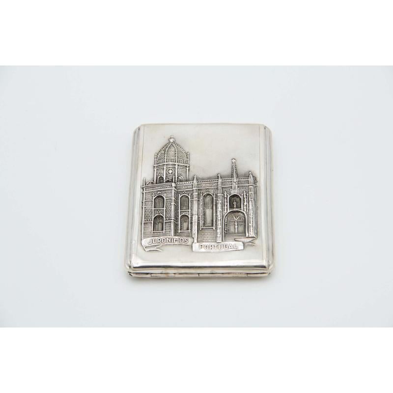 Description: Rectangular silver cigarette case with reliefs alluding to the Jerónimos Monastery. Metal: Silver. Origin: Portuguese. Mark: Eagle Head. Weight: 97.78 grams. Dimensions: 10.9cmx1.3cm. Content: 833/1000. Assay Mark: Yes, between 1938 and