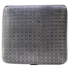 Silver cigarette case with square-shaped chiseled reliefs and a hinged lid