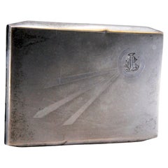 Silver cigarette case with three raised stripes on the lid