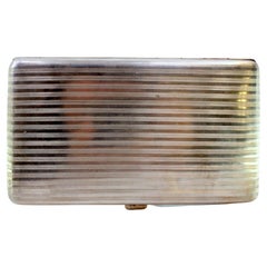 Silver cigarette case with top trim, hinged lid and gold interior