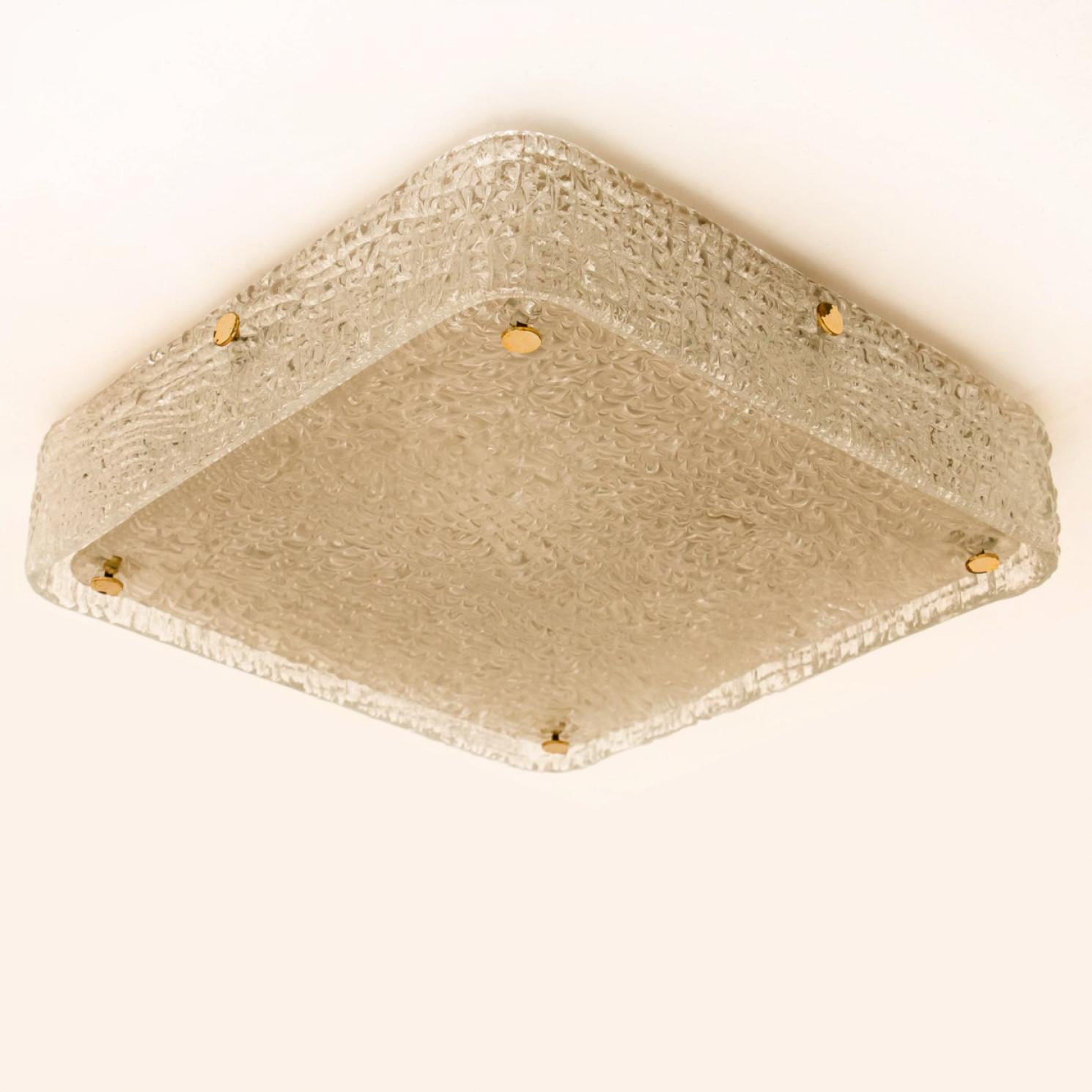 Brass flush mount by  by J.T. Kalmar, Vienna, Austria, manufactured in circa 1960. The glass shows a brass glass texture, which gives a diffuse light effect and a nice pattern on ceiling, walls and floor.
The stylish elegance of this lamp suits