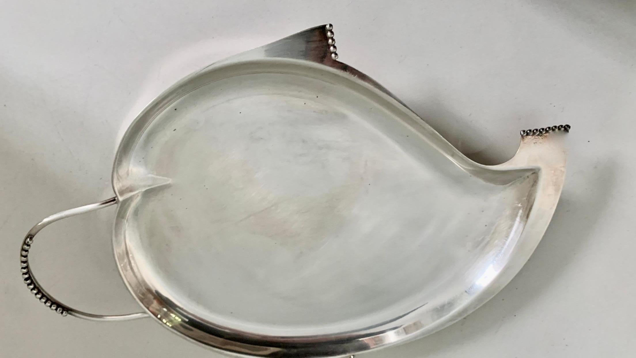 A very unique silver plate serving tray with influences of both Elsa Peretti and George Jensen. The amoeba like, organic shape with flared beaded edging gives a true sense of sophistication. From the bar to the cocktail table, a compliment to any