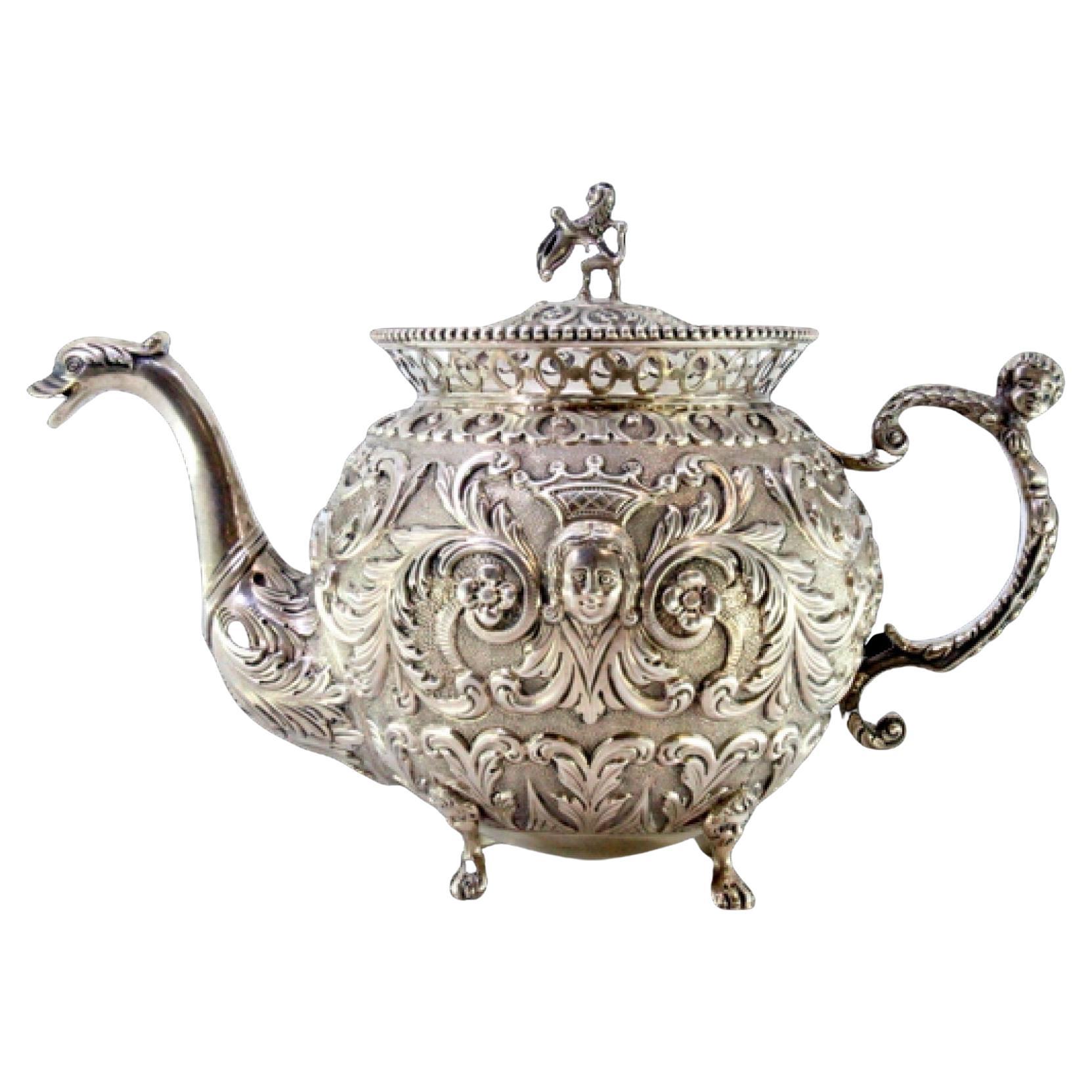 Silver coffee pot with embossed female and elf faces, claw-foot base For Sale