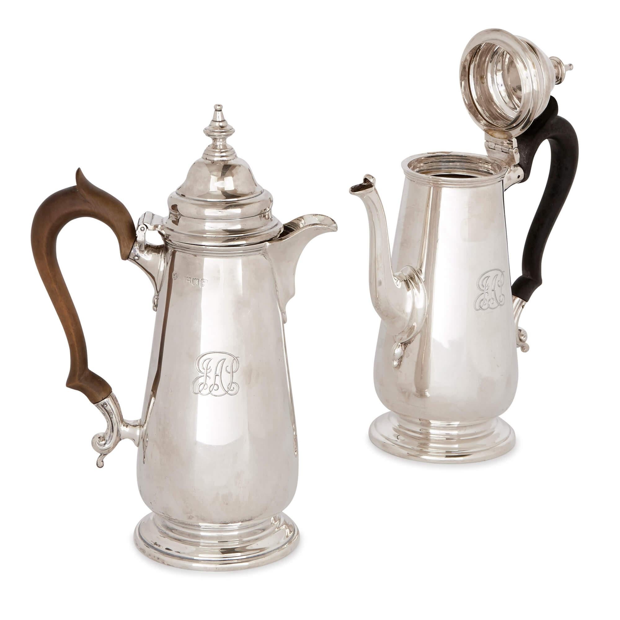 This classic English sterling silver coffee set is a simplified, elegant piece of artistry dating from the Edwardian period of the early 20th century. The set contains two coffee pots, a milk jug and a sugar bowl and spoon, all of which are