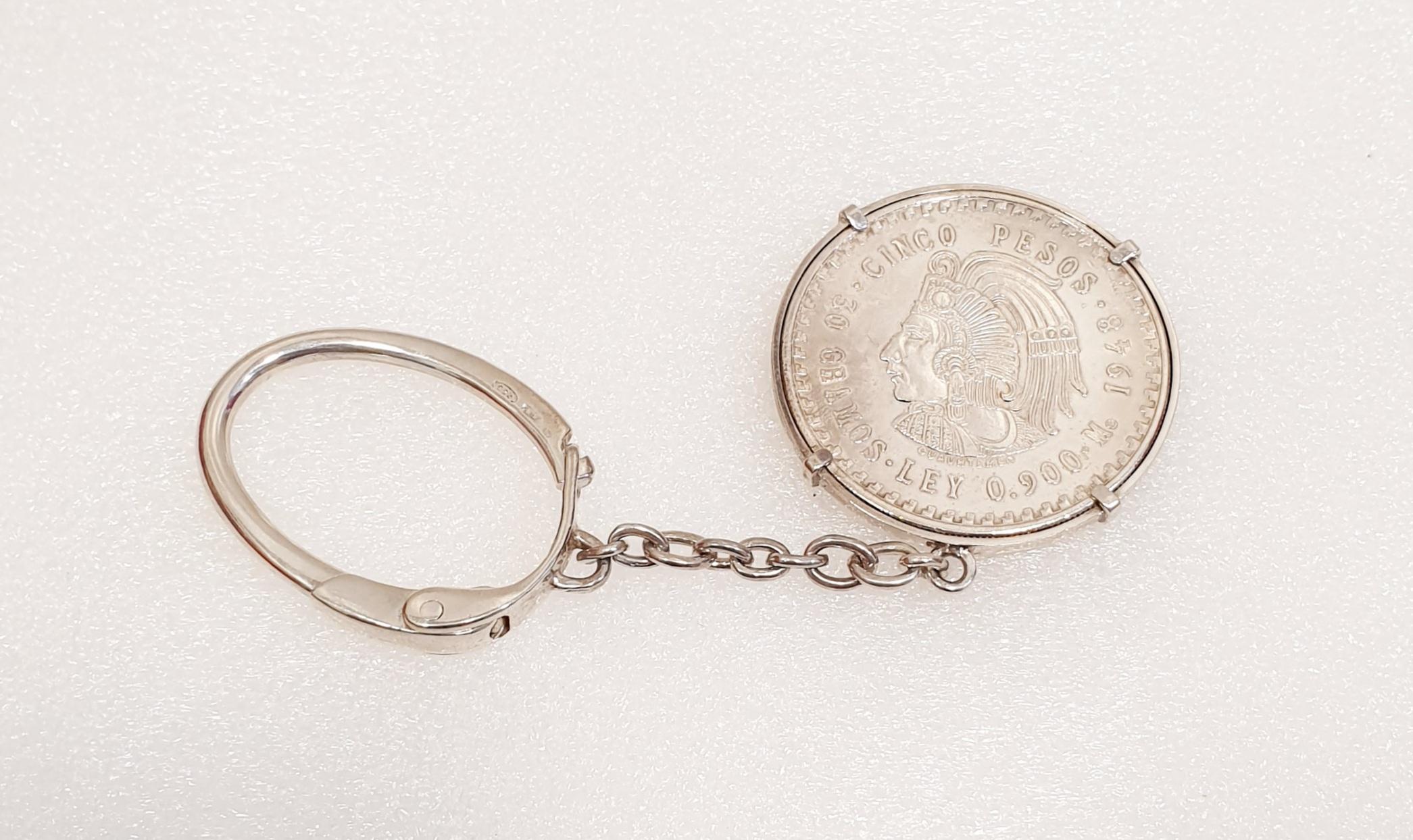 Silbermünze 5 Pesos 1947 Cuauhtemoc in seinem Schlüsselanhänger
Fünf Pesos Cuauhtémoc Silbermünze, Jahr 1947, mit seinem ursprünglichen Glanz in seinem Schlüsselring
Gewicht: 30 Gramm.      
Münzdurchmesser  4cm
Länge des Schlüsselrings  12,5cm
In