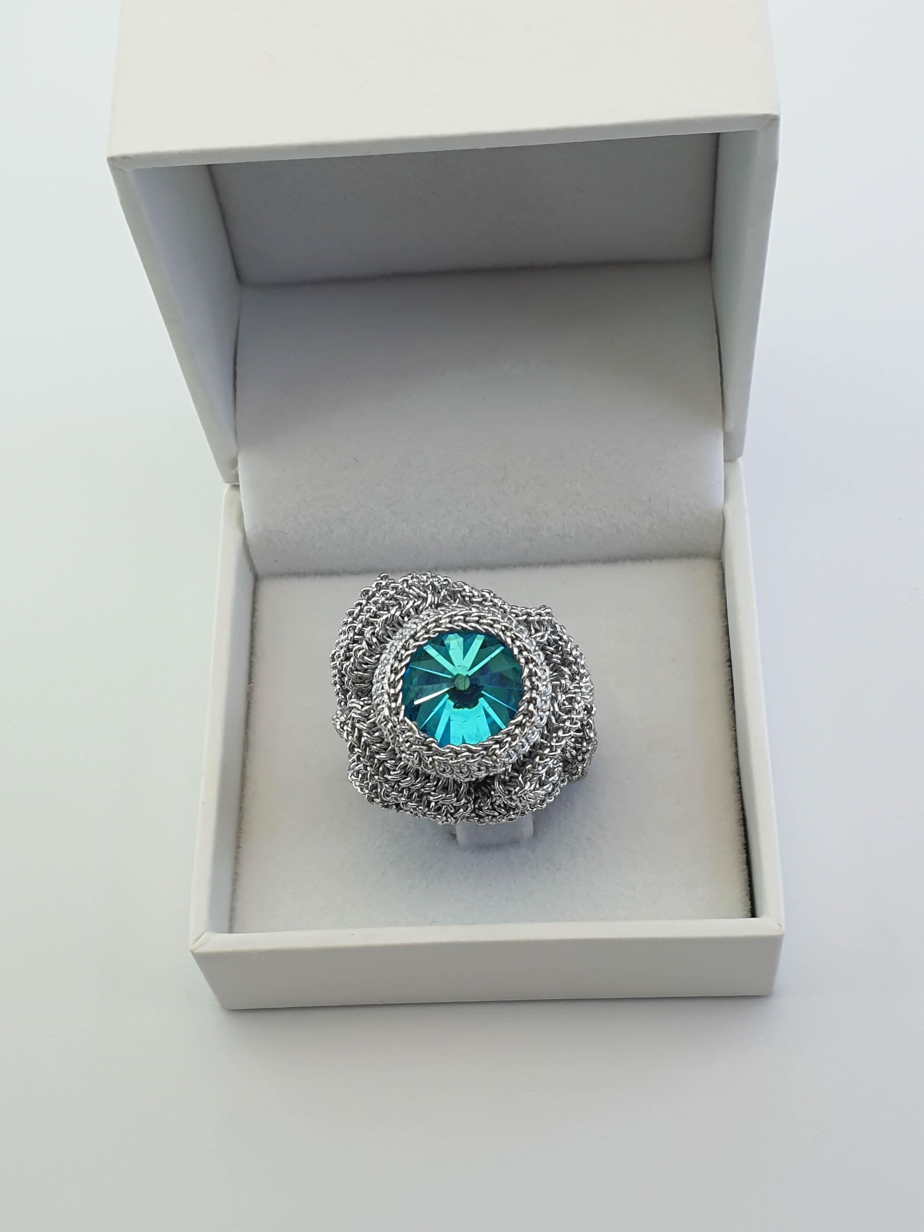 Contemporary handcrafted crochet  cocktail ring. Silver color thread, tightly crochet around sky blue color Swarovski Crystal. 
This ring is a US 6 size.
This ring can be custom made to size.

The ring is crochet with a smooth passing thread. It is