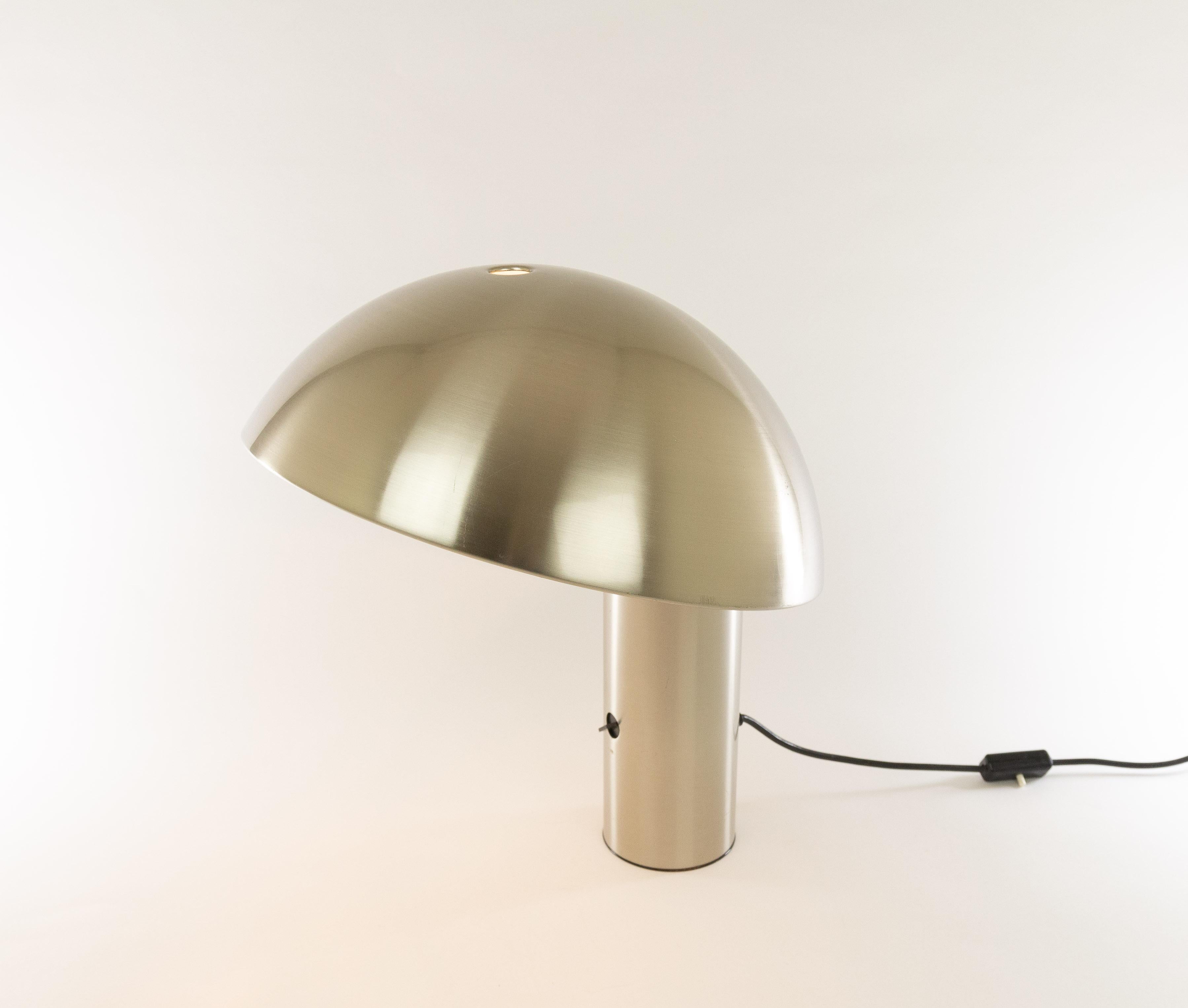 Silver colored Vaga table lamp, designed by Franco Mirenzi and produced by Valenti Luce in 1978.

The relatively heavy base provides a solid balance for the fairly large round metal top of the lamp. The lamp is made of metal and includes a