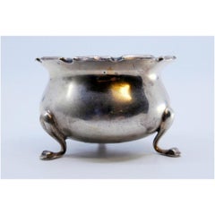 Silver compote dish with scalloped edge and set on three feet