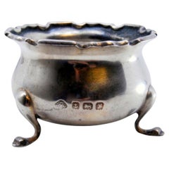 Silver compote dish with scalloped edge and set on three feet