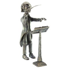 Silver conductor figure with baton and staff