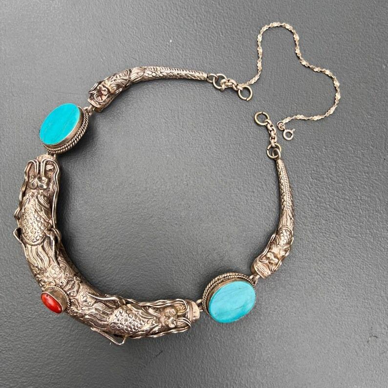Stunning vintage choker necklace, dating from the early to mid 20th century, is an exquisite example of craftsmanship from either Chinese or Tibetan traditions. Featuring Four intricately detailed dragon heads adorn the necklace, with large