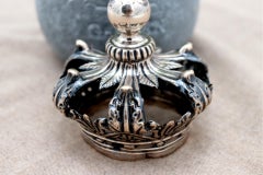 Silver crown with applications and reliefs with a topped pommel