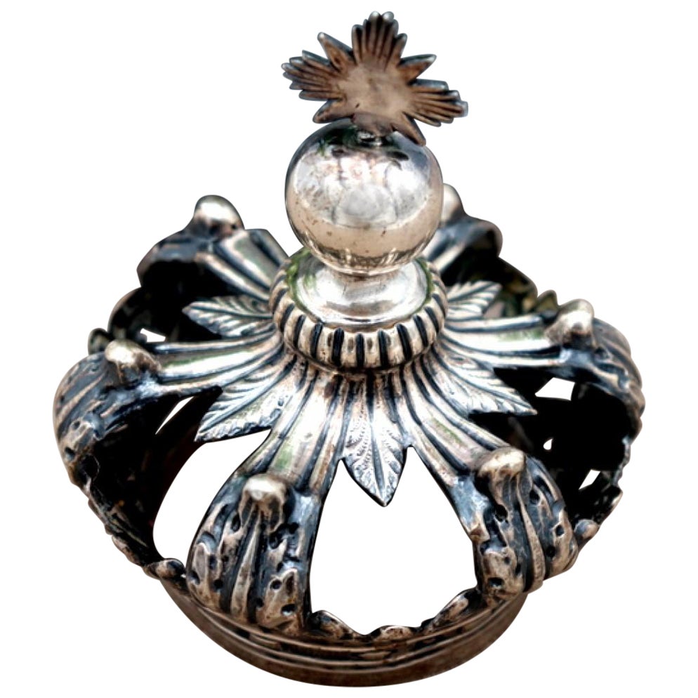 Silver crown with applications and reliefs with a topped pommel