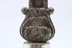 Silver crucifix with reliefs, resting on a plinth with friezes around it