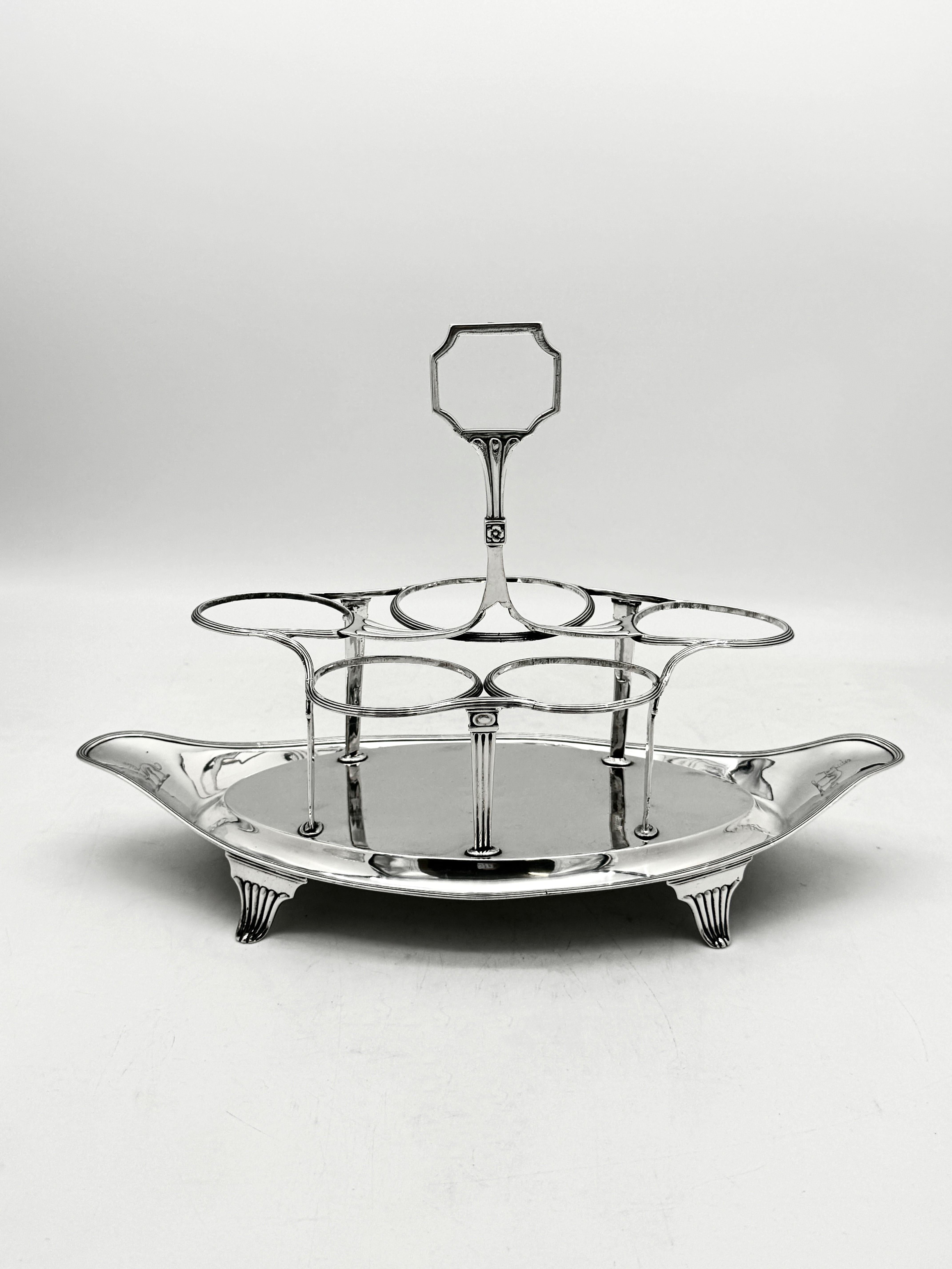 Antica ampolla d'argento inglese di George III, realizzata da Henry Chawner e con marchio Londra 1795.

Questa elegante e affascinante ampolla da tavolo ha la classica forma a barca con un bordo a filetto e le cinque bottiglie di vetro sono