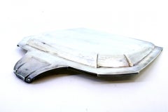 Silver crumb catcher with friezes, reliefs and a handle with curls