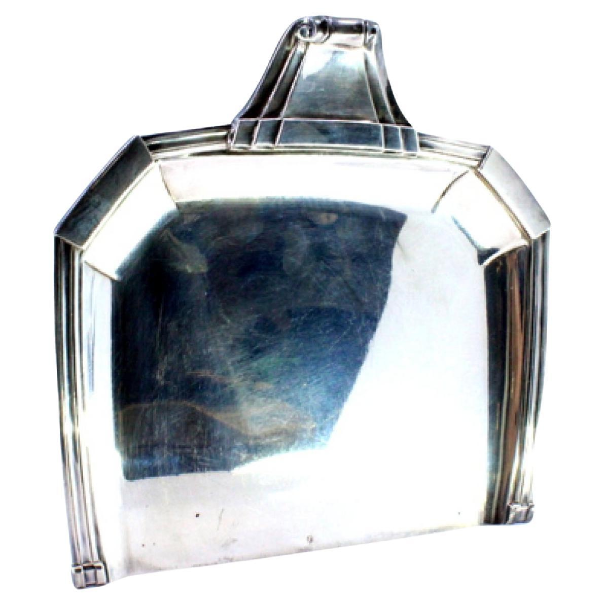 Silberner Krümelfänger mit Friesen, Reliefs und einem Griff mit Locken