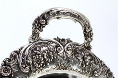 Silver crumb catcher with revealed floral motifs surrounding monogram card