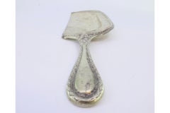 Silver crumb collector with reliefs on the handle and pearl trim