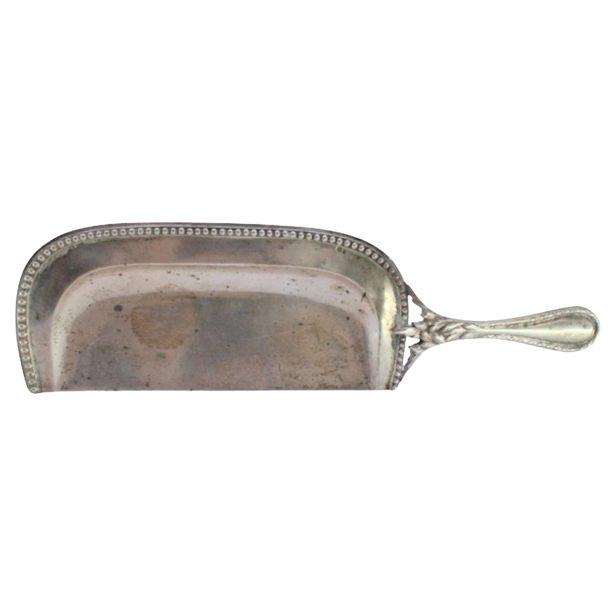 Silberner Krümelsammler mit Reliefs auf dem Griff und Perlenbesatz