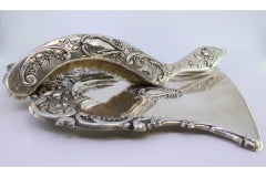 Silver crumb set w/ floral & scroll reliefs around monogram card