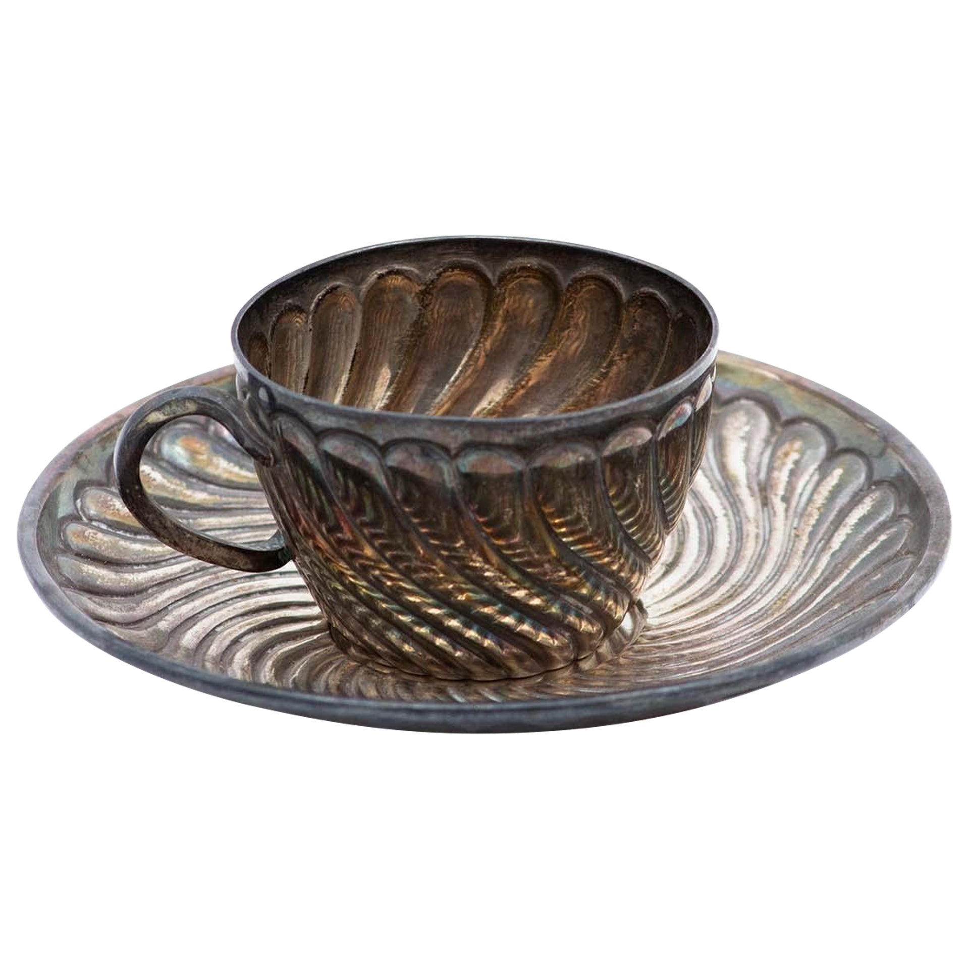 Silver cup and saucer with concentric reliefs