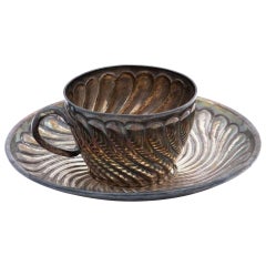 Silver cup and saucer with concentric reliefs
