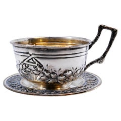 Antique Silver cup and saucer with embossed floral motifs and appliquéd handle
