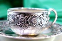 Silver cup and saucer with engraved reliefs and smooth handle