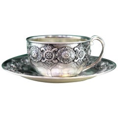 Silver cup and saucer with engraved reliefs and smooth handle
