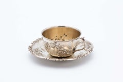 Silver cup and saucer with floral motifs