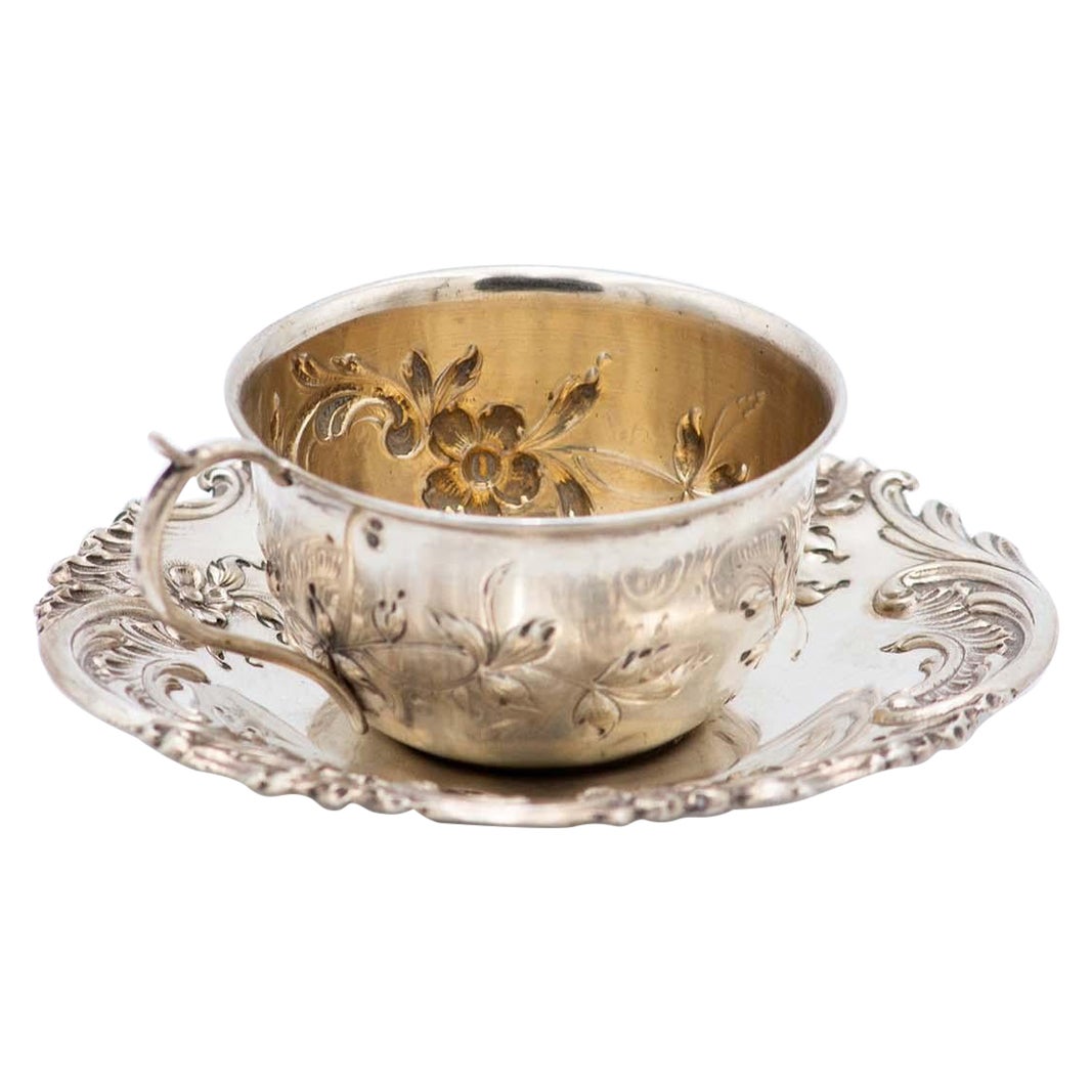 Silver cup and saucer with floral motifs