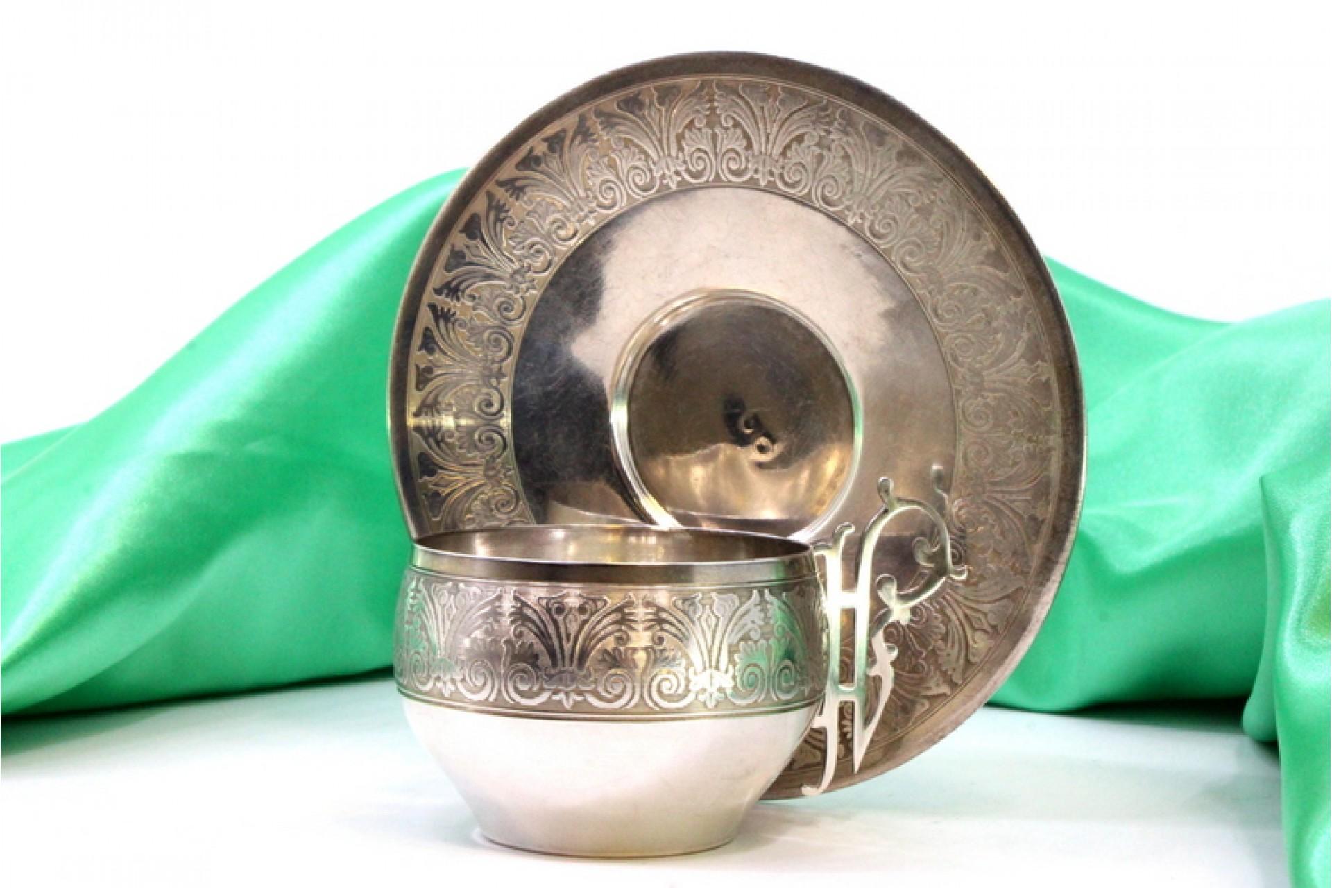 Silver cup and saucer with reliefs and cutouts on the handles (Europäisch) im Angebot
