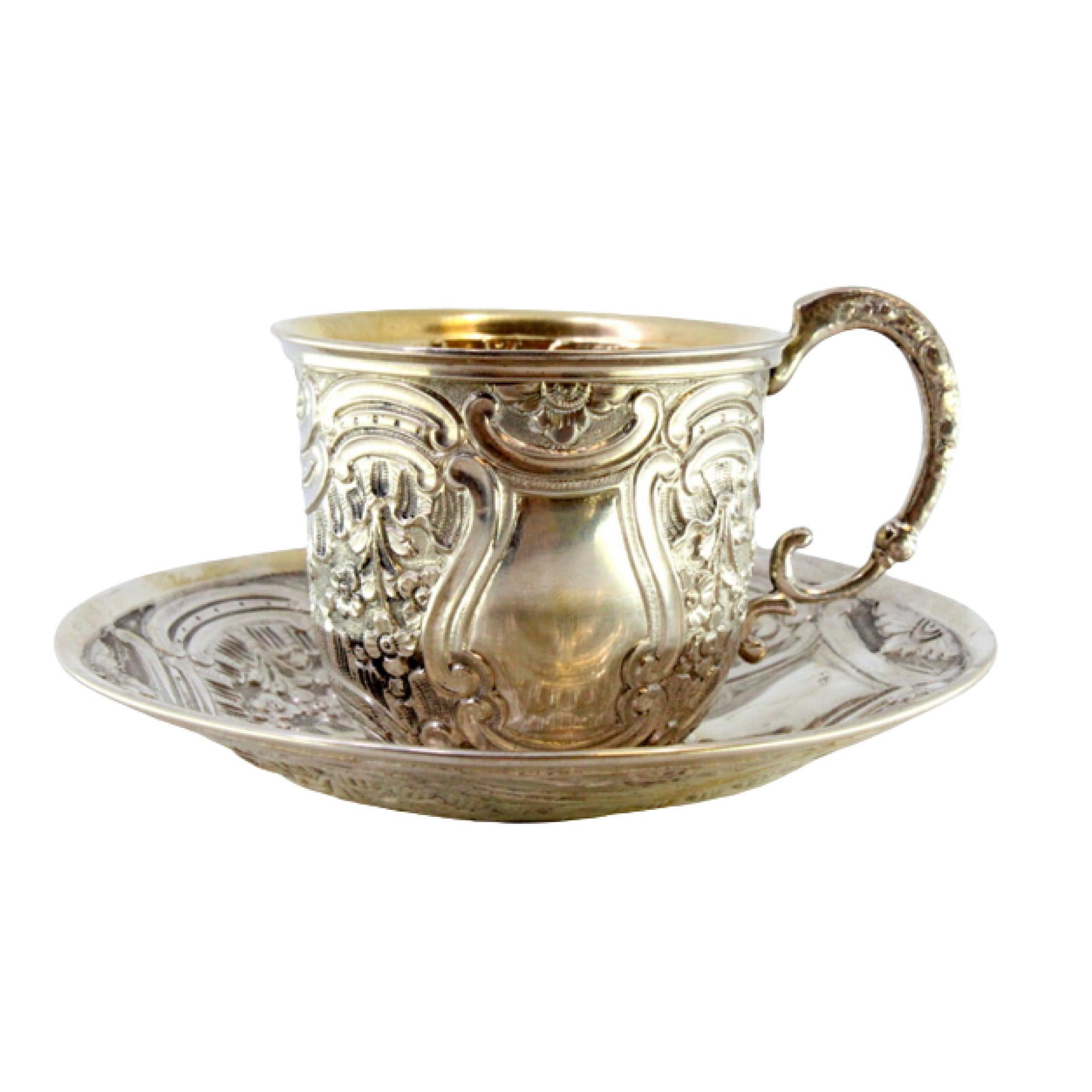 Silver cup and saucer with reliefs and gold interior