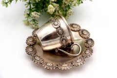 Silver cup and saucer with reliefs