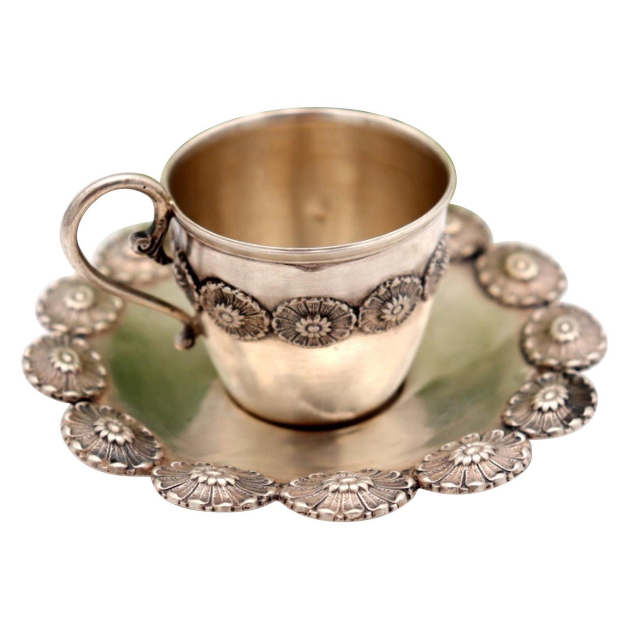 Silver cup and saucer with reliefs